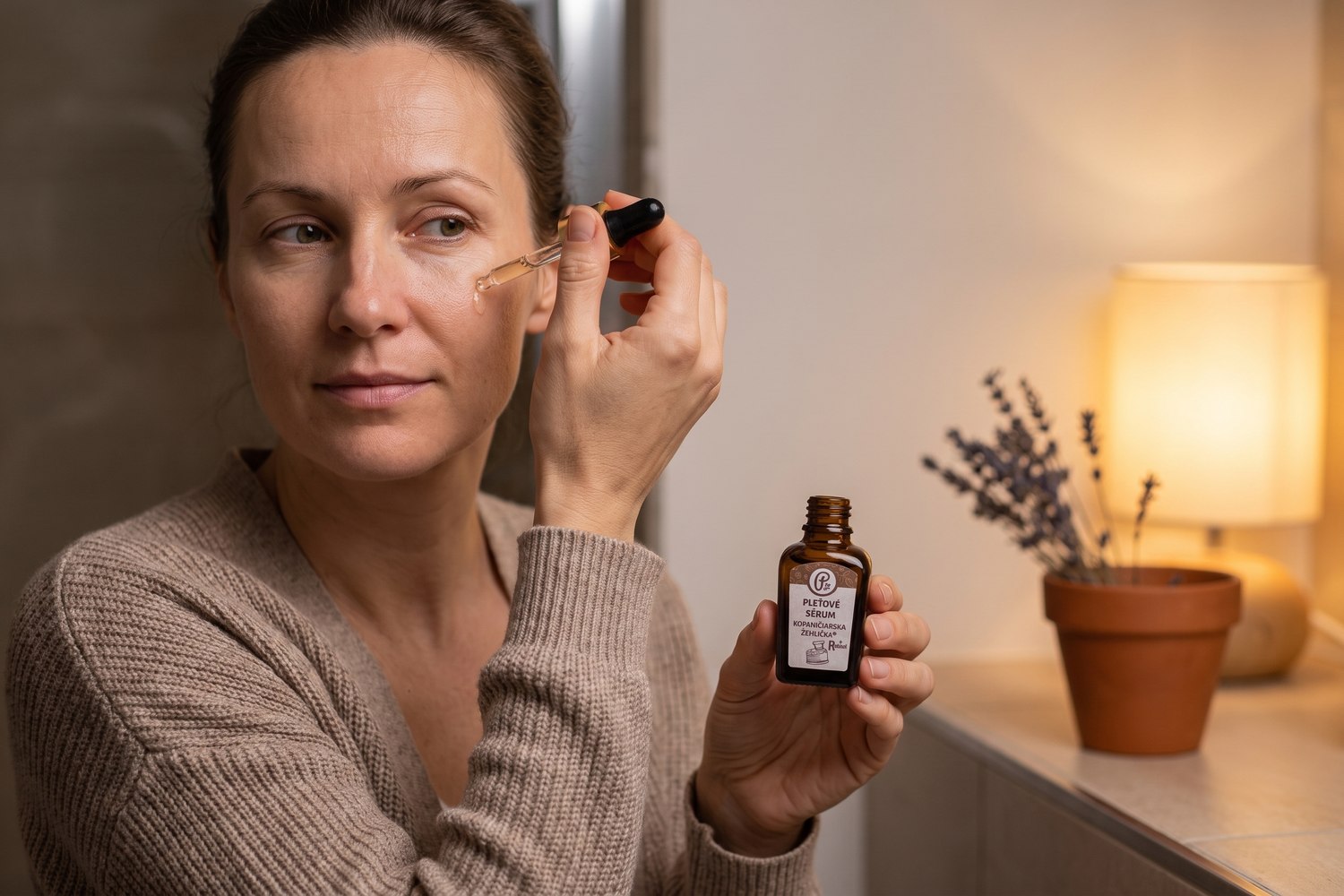 Nő az esti fürdőszobai tükör előtt, ahogy retinol szérumot visz fel a tisztított arcbőrére